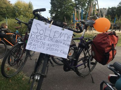 Fahrrad mit Kinderplakat: "Sollen die Kinder drinen bleiben, damit die Autos draßen spielen können?"